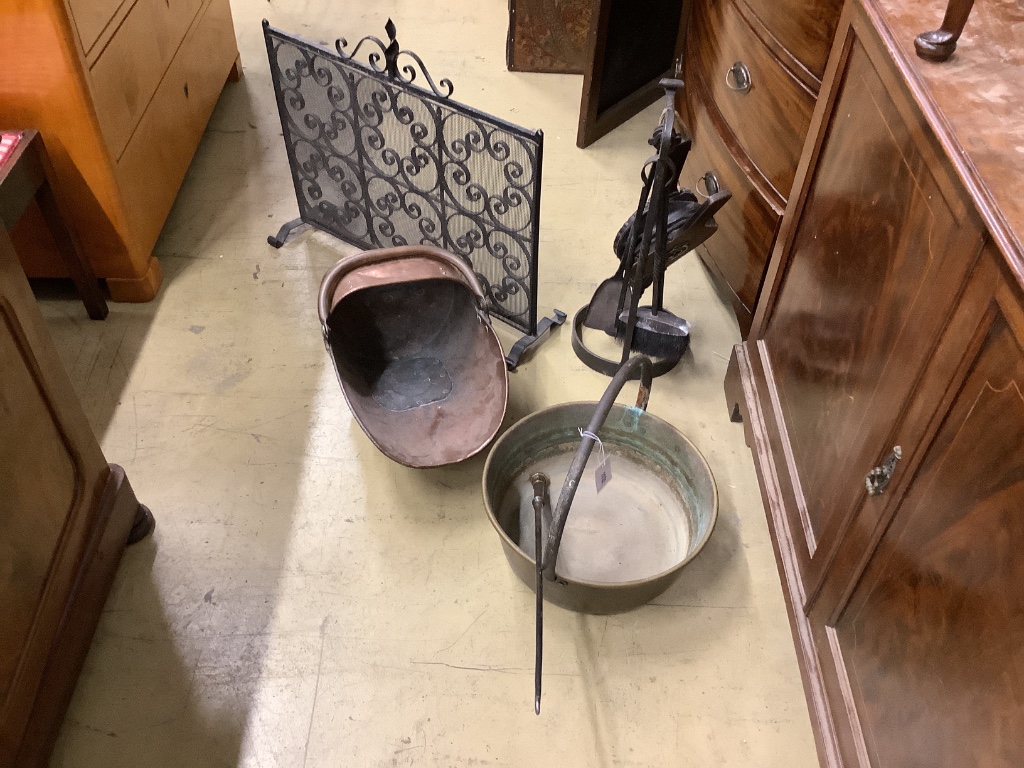 An ironwork fireside companion set, a Victorian copper coal scuttle and a brass jam pan (3)